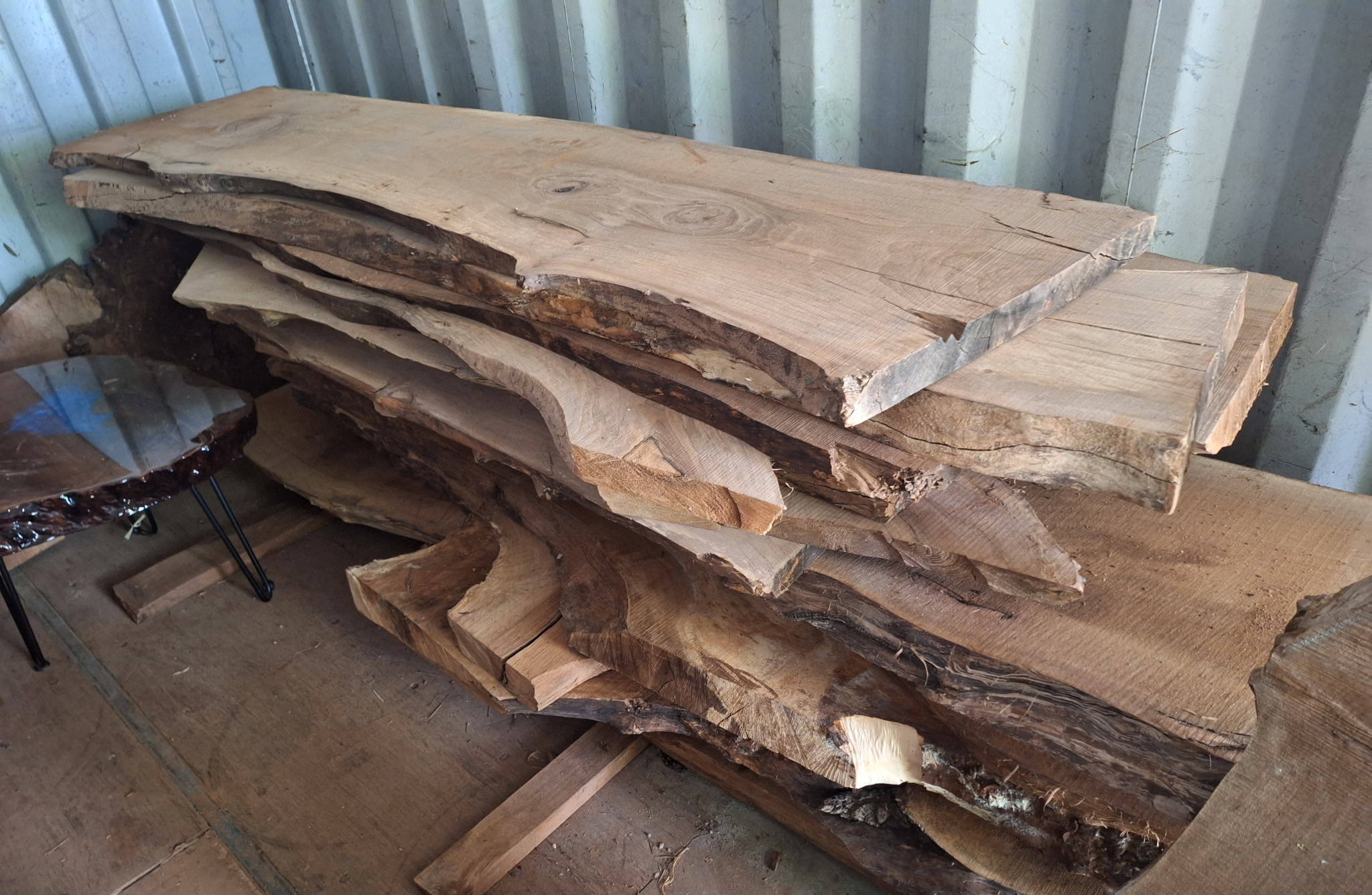 Live-edge walnut slabs stacked in the yard.